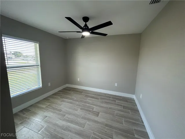 wooden floor in an empty room with a window