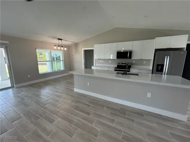 a kitchen with stainless steel appliances a refrigerator sink and microwave