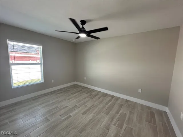 an empty room with a window and a ceiling fan