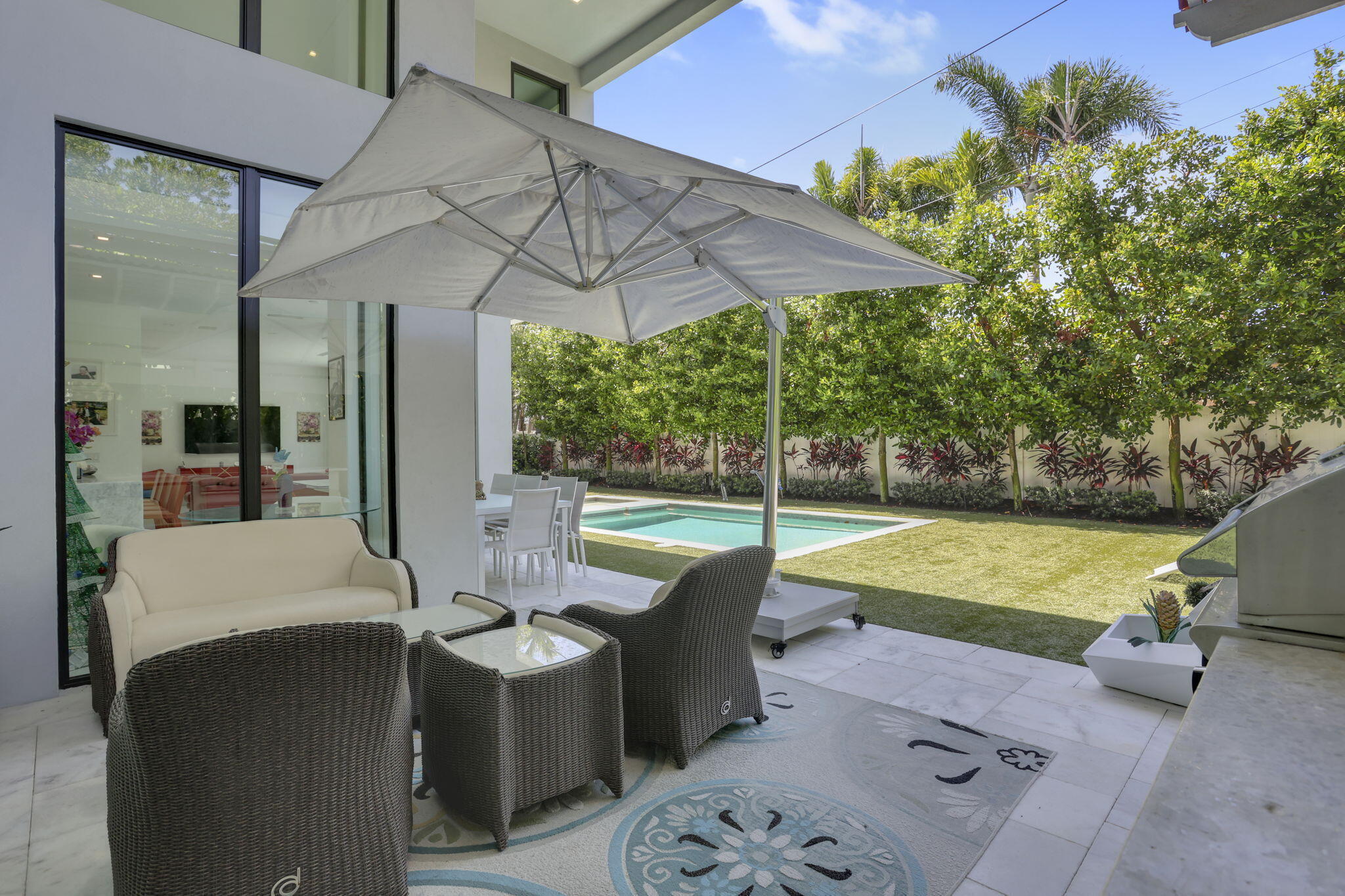 234 Northeast 4th Street Boca Raton, FL 33432 - Photo 25 of 72 a view of a patio with a table chairs and a swimming pool