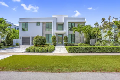 a front view of a house with a yard and potted plants