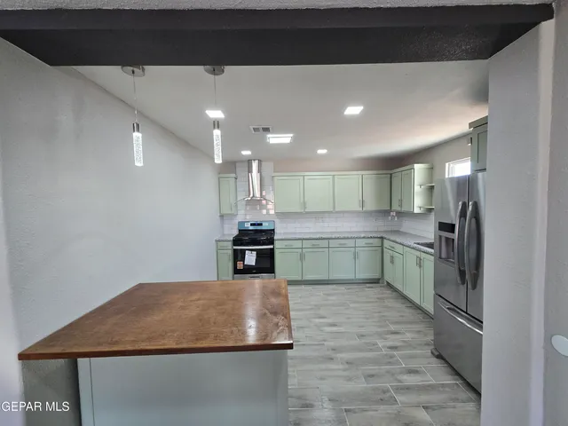 a kitchen with stainless steel appliances a refrigerator sink and stove