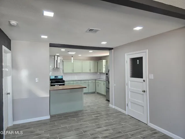 a kitchen with stainless steel appliances a refrigerator and a stove top oven