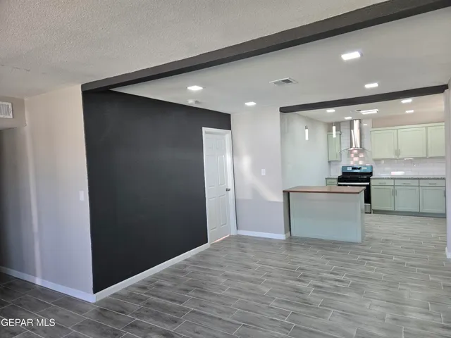 a view of kitchen with stainless steel appliances kitchen island granite countertop a refrigerator and a sink