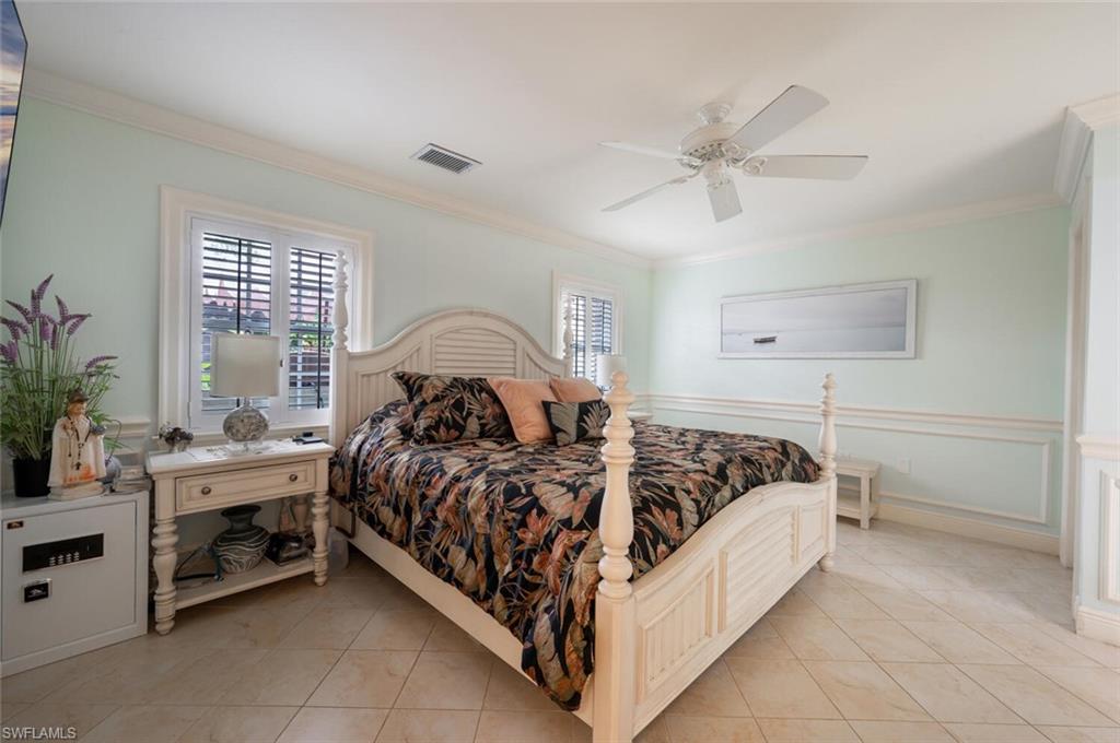 644 Augusta Boulevard Naples, FL 34113 - Photo 16 of 40 a bed sitting in a bedroom next to a window with potted plant