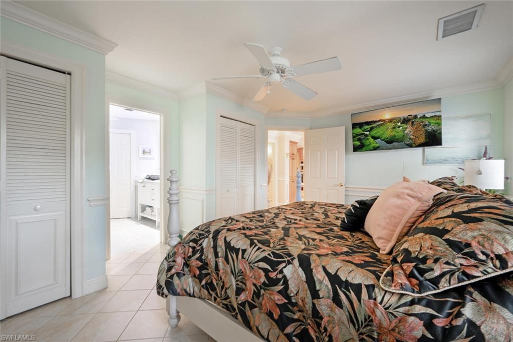 644 Augusta Boulevard Naples, FL 34113 - Photo 17 of 40 a bedroom with a bed and a mirror