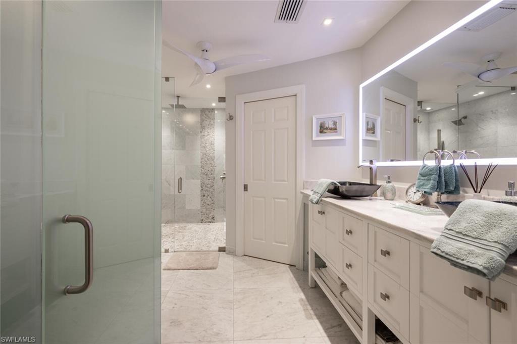 644 Augusta Boulevard Naples, FL 34113 - Photo 18 of 40 a bathroom with a double vanity sink a mirror and a shower