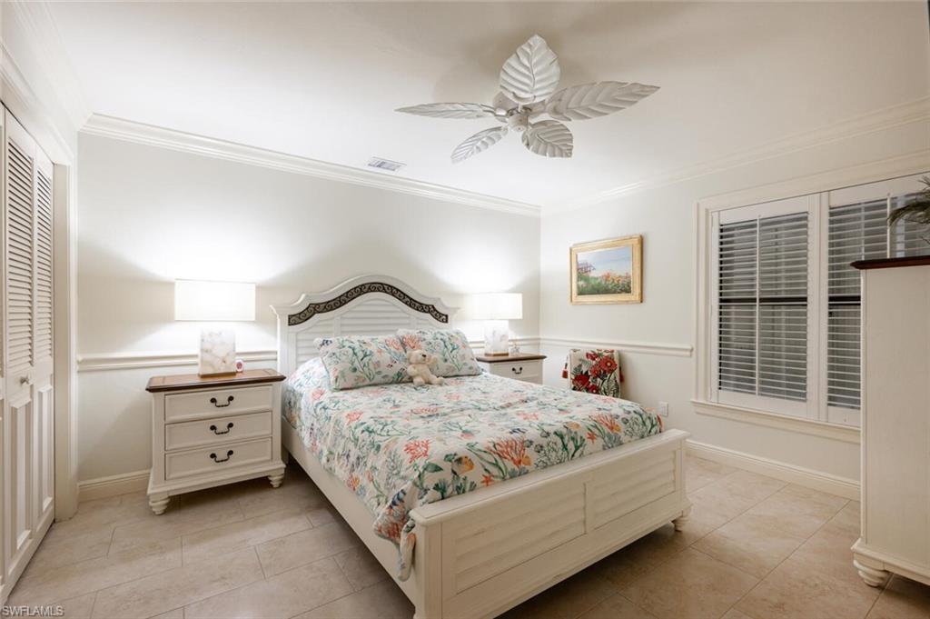 644 Augusta Boulevard Naples, FL 34113 - Photo 21 of 40 a bedroom with a bed and a chandelier