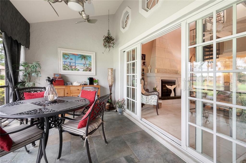 644 Augusta Boulevard Naples, FL 34113 - Photo 28 of 40 a dining room with furniture a floor to ceiling window and a flat screen tv