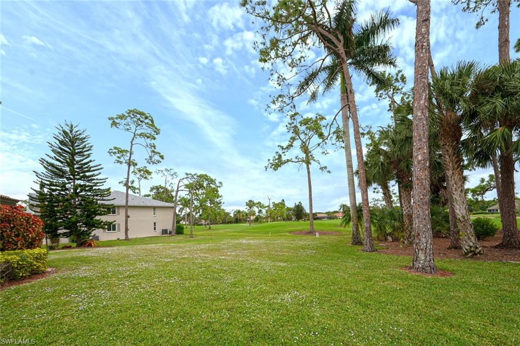 644 Augusta Boulevard Naples, FL 34113 - Photo 39 of 40 a view of a white house with a big yard and palm trees