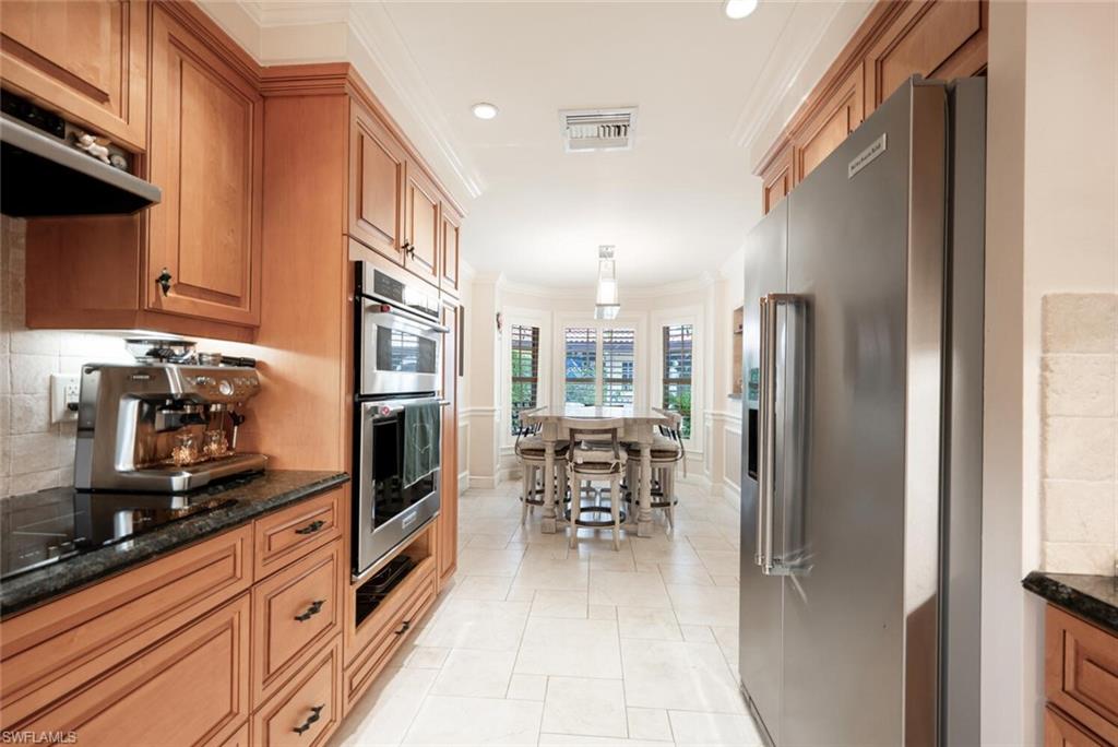 644 Augusta Boulevard Naples, FL 34113 - Photo 8 of 40 a kitchen with stainless steel appliances granite countertop a refrigerator and a stove top oven