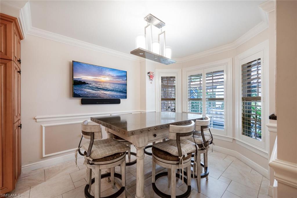 644 Augusta Boulevard Naples, FL 34113 - Photo 10 of 40 a dining room with furniture a chandelier and window