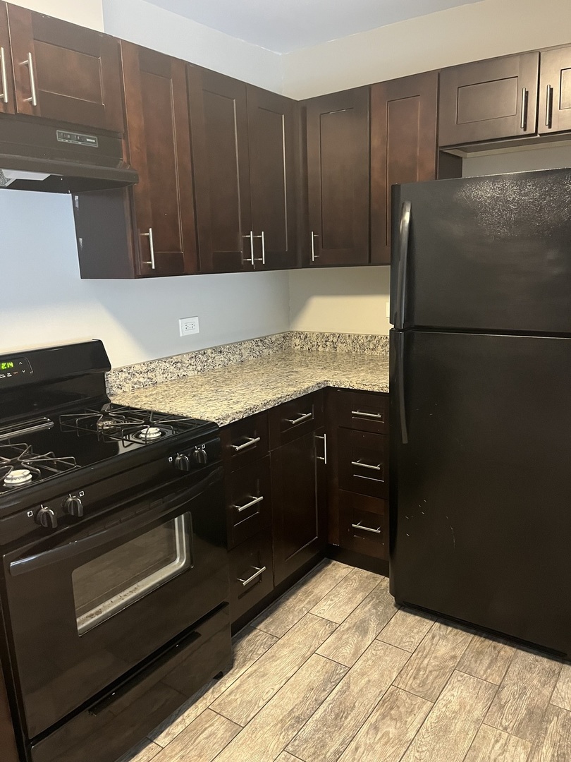 7501 SW Highway, Unit 5 Worth, IL 60482 - Photo 4 of 7 a kitchen with granite countertop stainless steel appliances and wooden cabinets