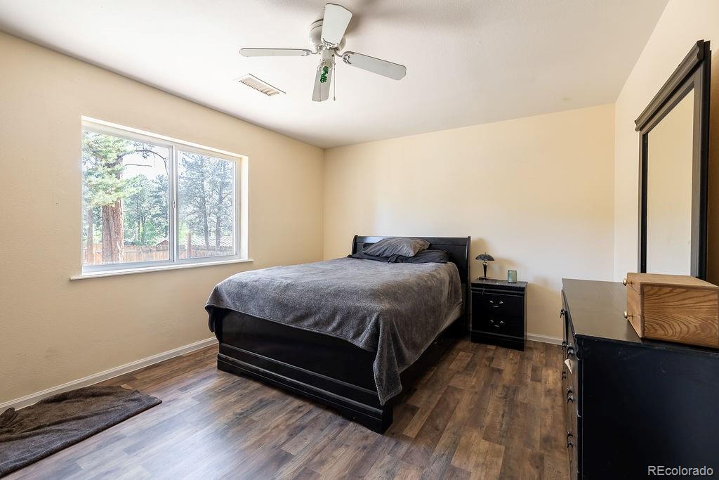 154 Cowan Road Bailey, CO 80421 - Photo 15 of 30 a spacious bedroom with a bed and wooden floor