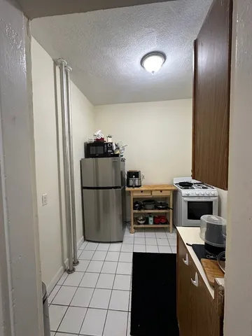 a kitchen with a refrigerator and a stove top oven
