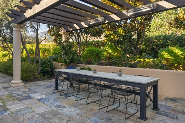 a roof deck with table and chairs and potted plants