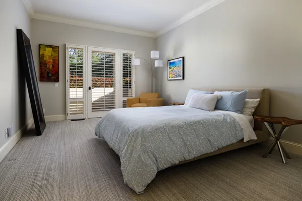 a bedroom with a bed a mirror and a window