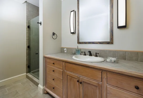 a bathroom with a granite countertop sink vanity and mirror