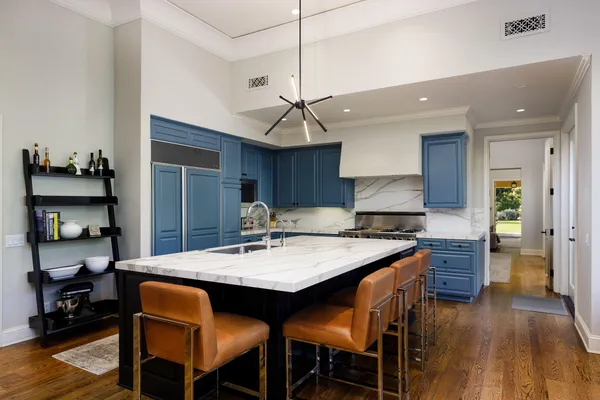 a kitchen with a dining table cabinets stainless steel appliances and wooden floor