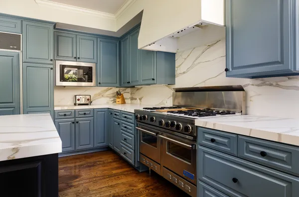 a kitchen with a stove and white cabinets