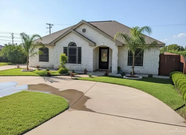 a front view of a house with a yard and potted plants