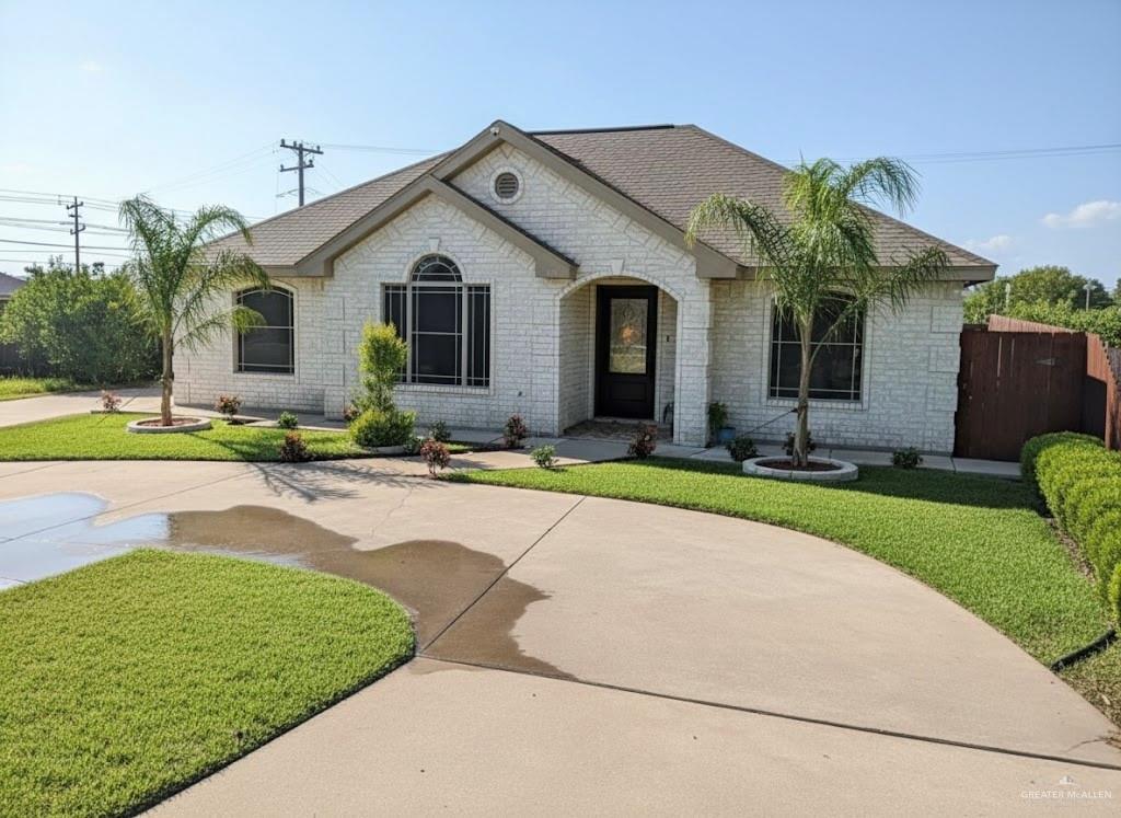 a front view of a house with a yard and potted plants