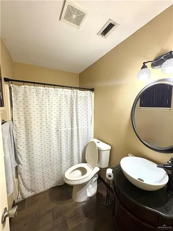 an empty room with a ceiling fan and wooden floor