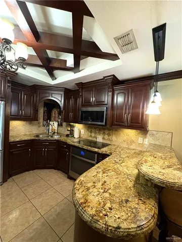 a kitchen with stainless steel appliances granite countertop a sink and a stove