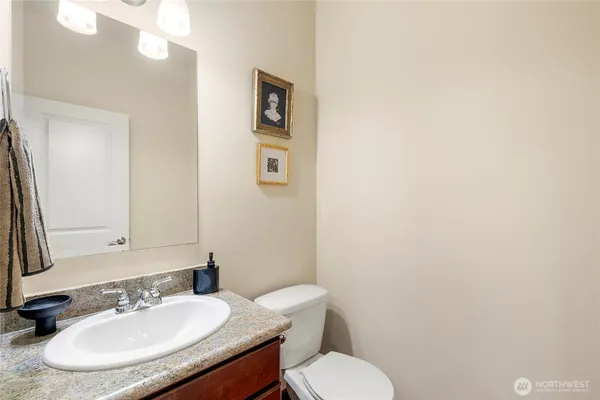 a bathroom with a toilet a sink and mirror