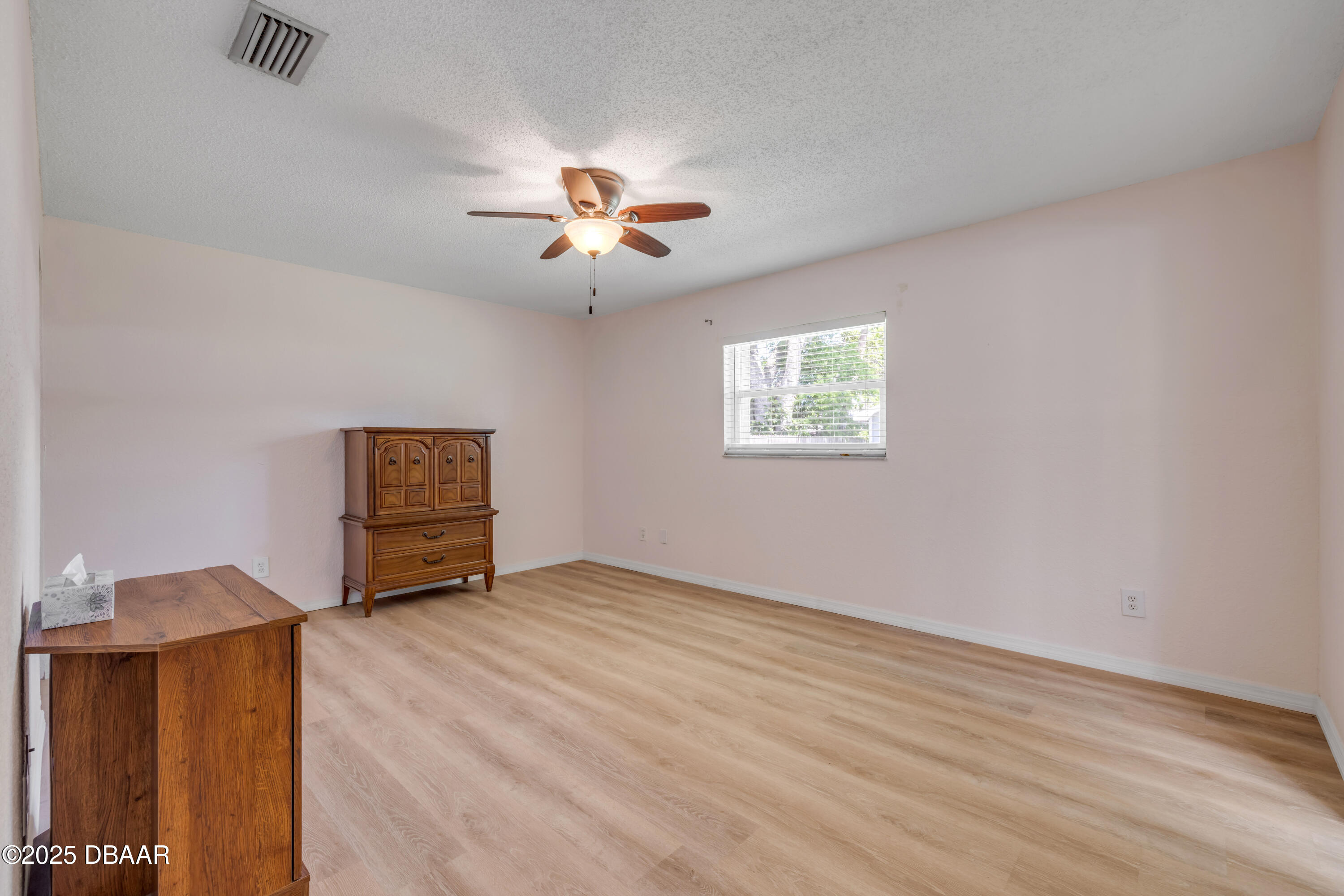 1851 Pine Tree Drive Edgewater, FL 32141 - Photo 12 of 29 a view of an empty room with a window and wooden floor