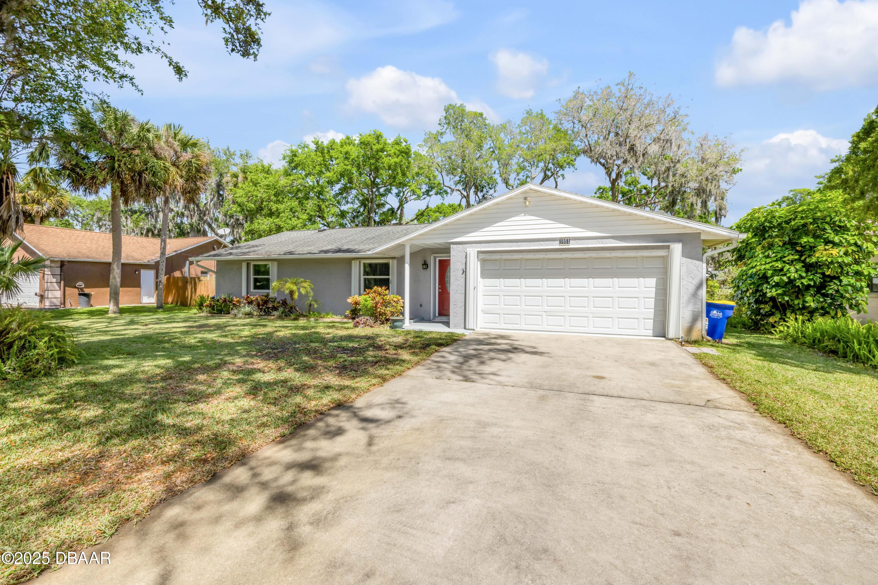 1851 Pine Tree Drive Edgewater, FL 32141 - Photo 2 of 29 a front view of a house with a yard and garage