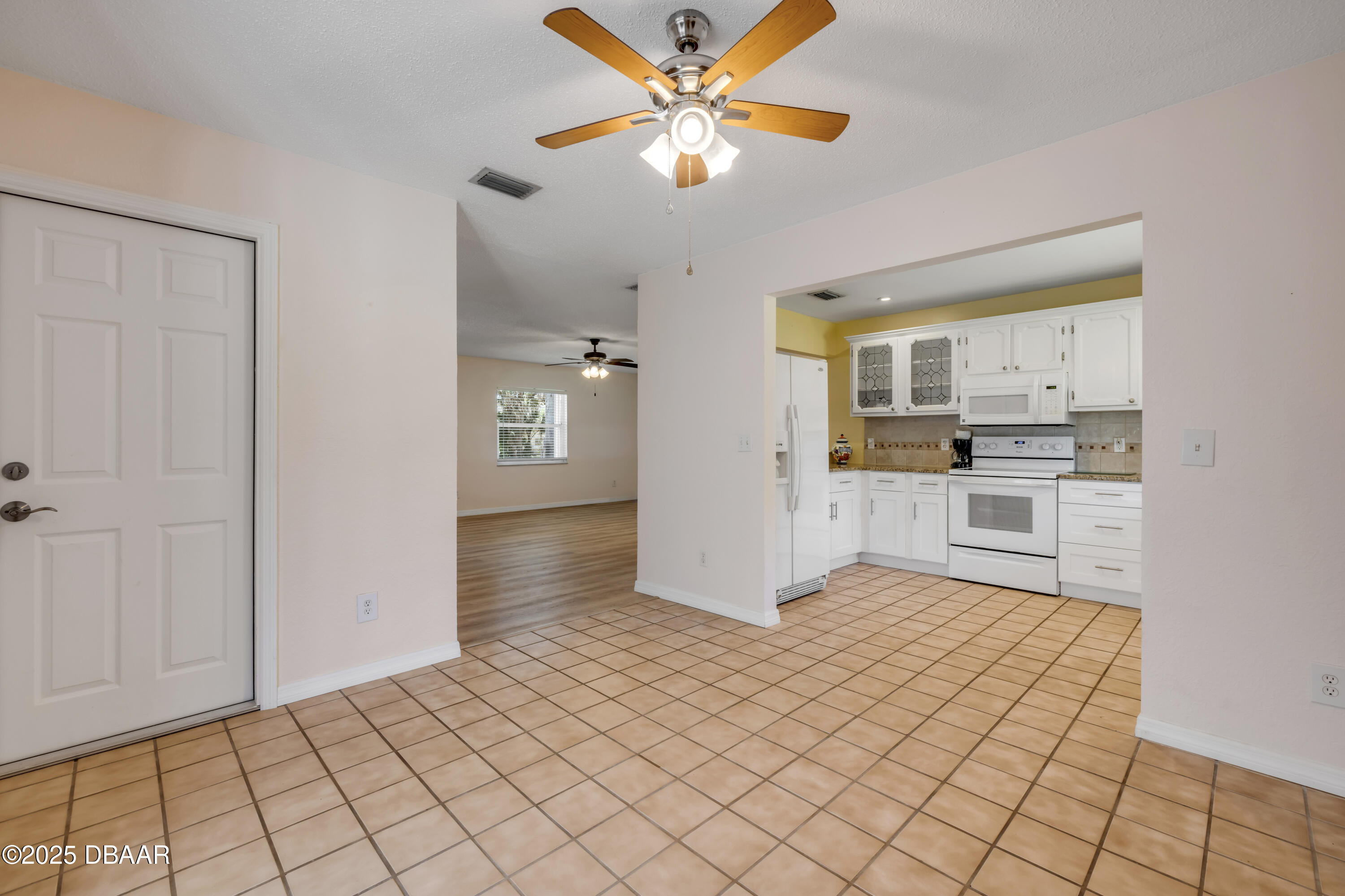 1851 Pine Tree Drive Edgewater, FL 32141 - Photo 7 of 29 a view of a kitchen with an entryway and a refrigerator