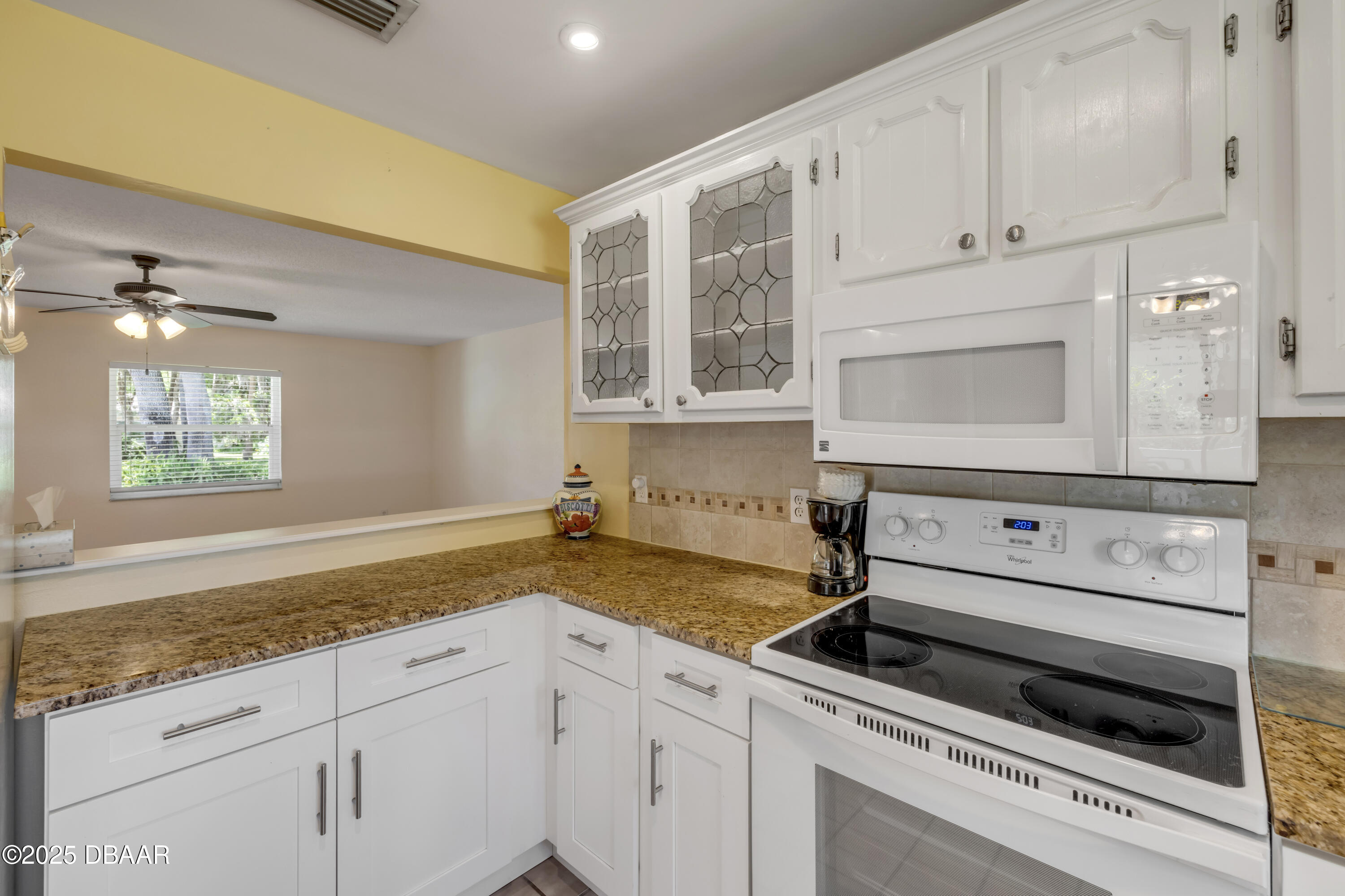 1851 Pine Tree Drive Edgewater, FL 32141 - Photo 9 of 29 a kitchen with granite countertop white cabinets and white appliances