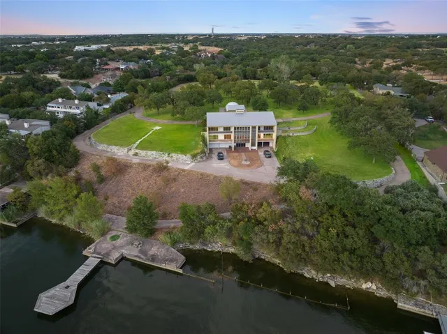 an aerial view of a house with a garden and lake view