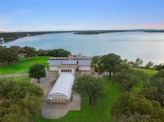 an aerial view of a house with pool a yard and lake view