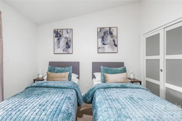 a bedroom with two beds and a painting on the wall