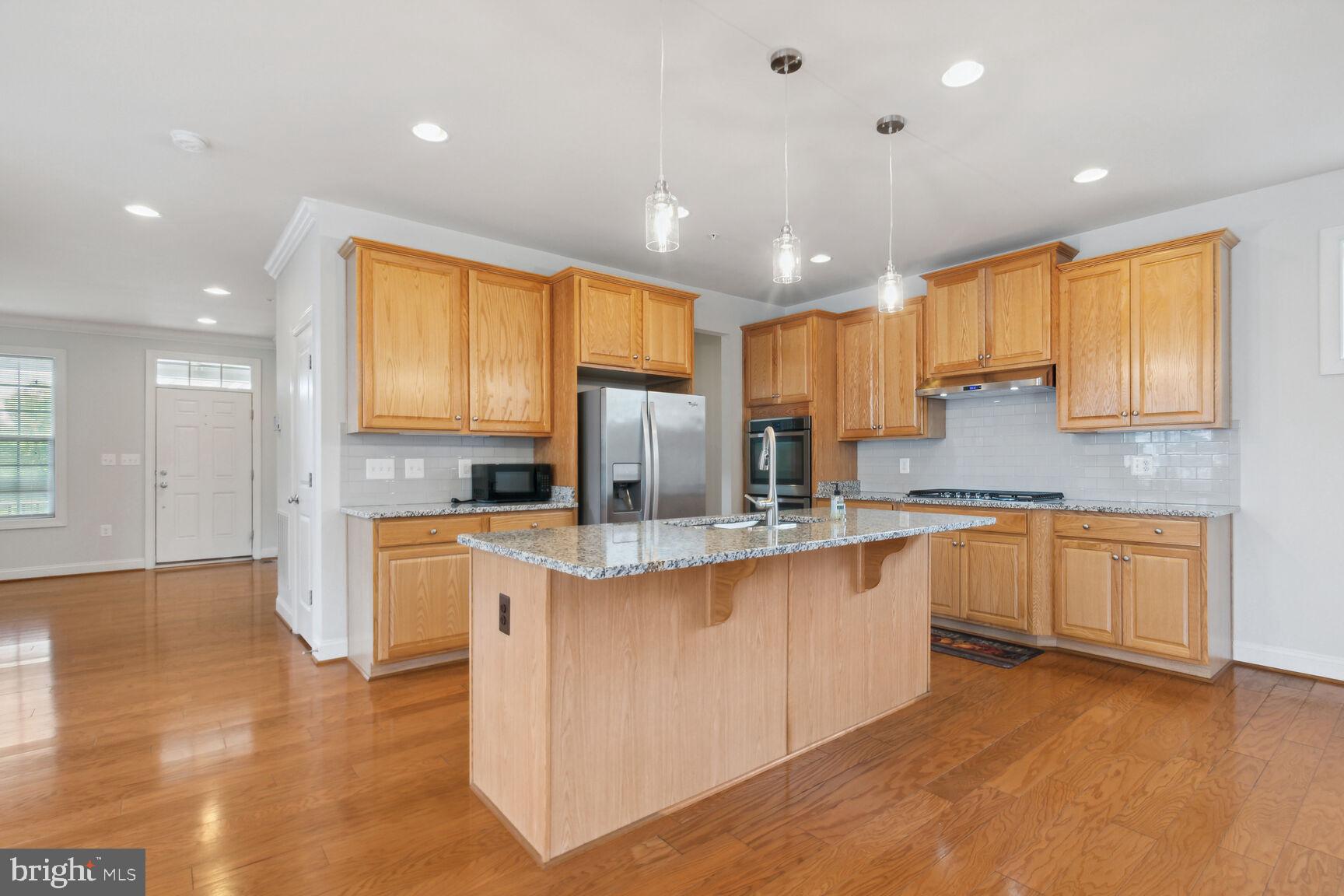 13601 Soaring Wing Lane Silver Spring, MD 20906 - Photo 8 of 53 a kitchen with stainless steel appliances granite countertop a sink a stove a refrigerator cabinets and a large window