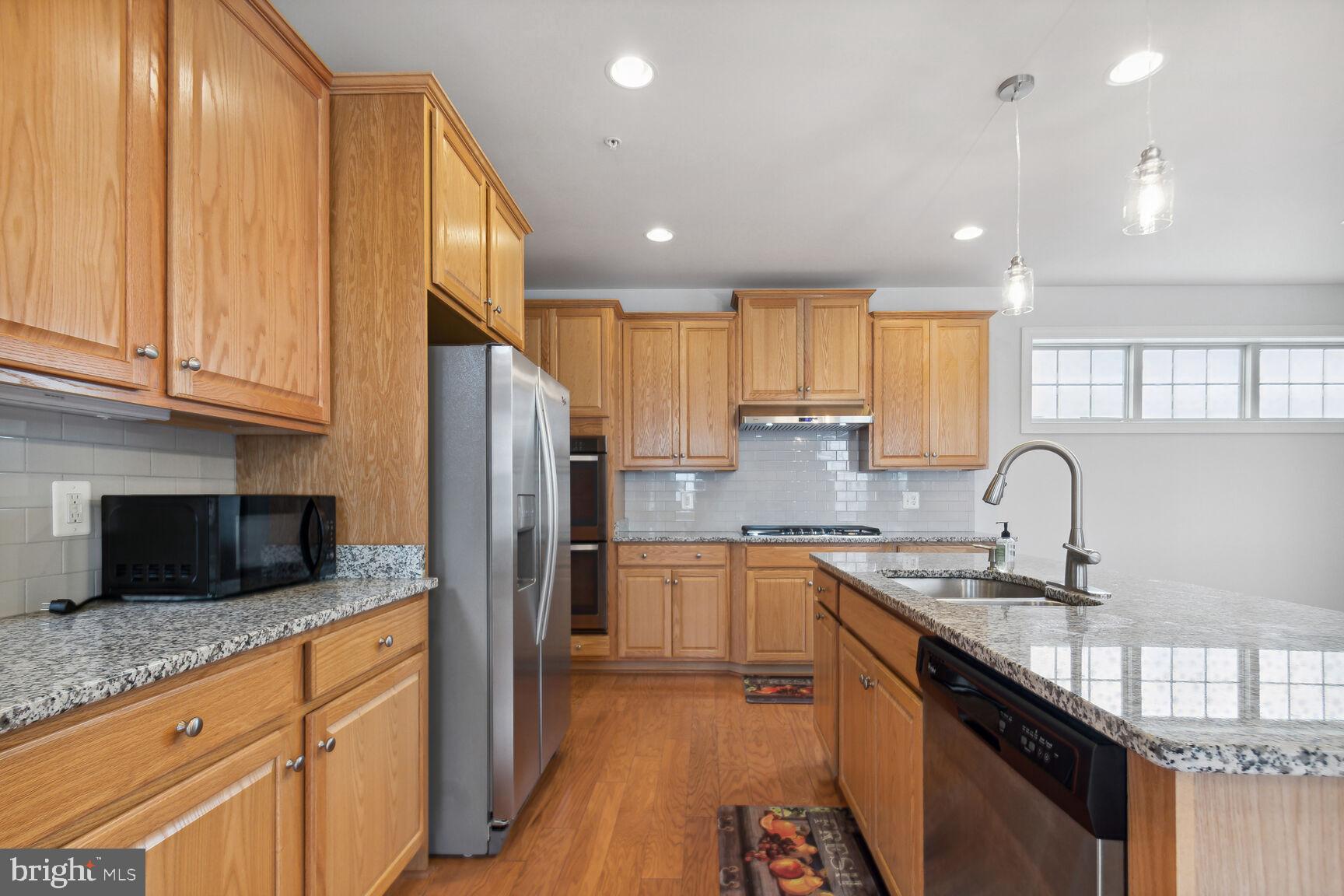 13601 Soaring Wing Lane Silver Spring, MD 20906 - Photo 10 of 53 a kitchen with stainless steel appliances granite countertop refrigerator a sink a stove a microwave and island