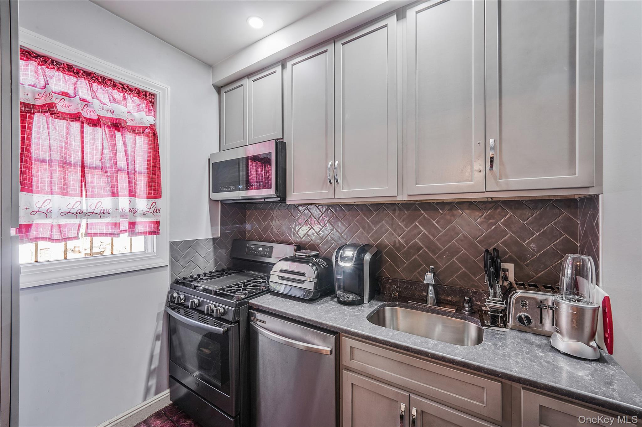 141 Branton Street Brooklyn, NY 11236 - Photo 9 of 20 a kitchen with stainless steel appliances granite countertop a sink a stove and a granite counter tops with white cabinets