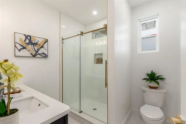 a bathroom with a shower a toilet and a sink