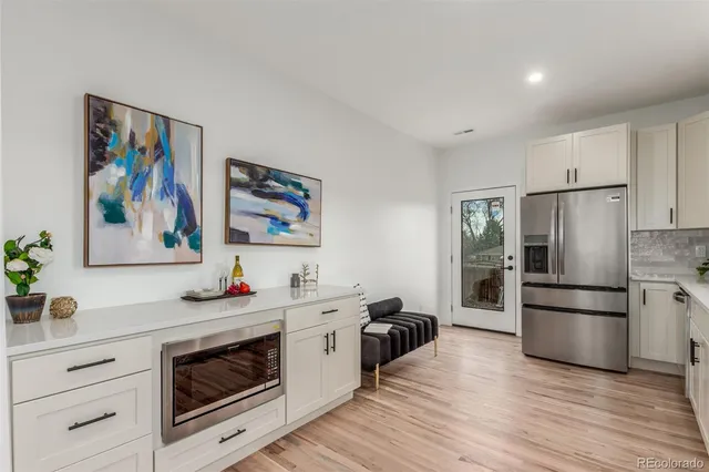 a kitchen with stainless steel appliances a stove a refrigerator and a hard wood floor