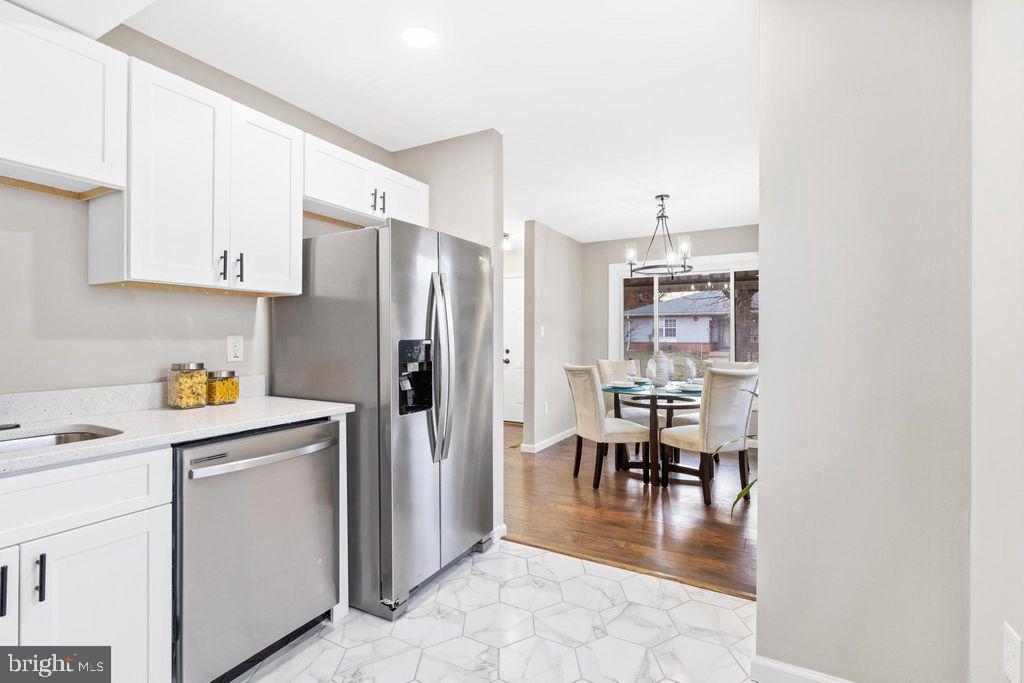 424 53rd Street Southeast Washington, DC 20019 - Photo 11 of 40 a kitchen with granite countertop a refrigerator a stove a dining table and chairs