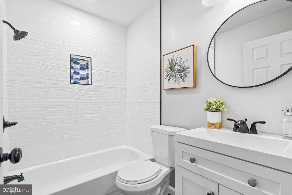 424 53rd Street Southeast Washington, DC 20019 - Photo 23 of 40 a bathroom with a sink a mirror a toilet and a bathtub