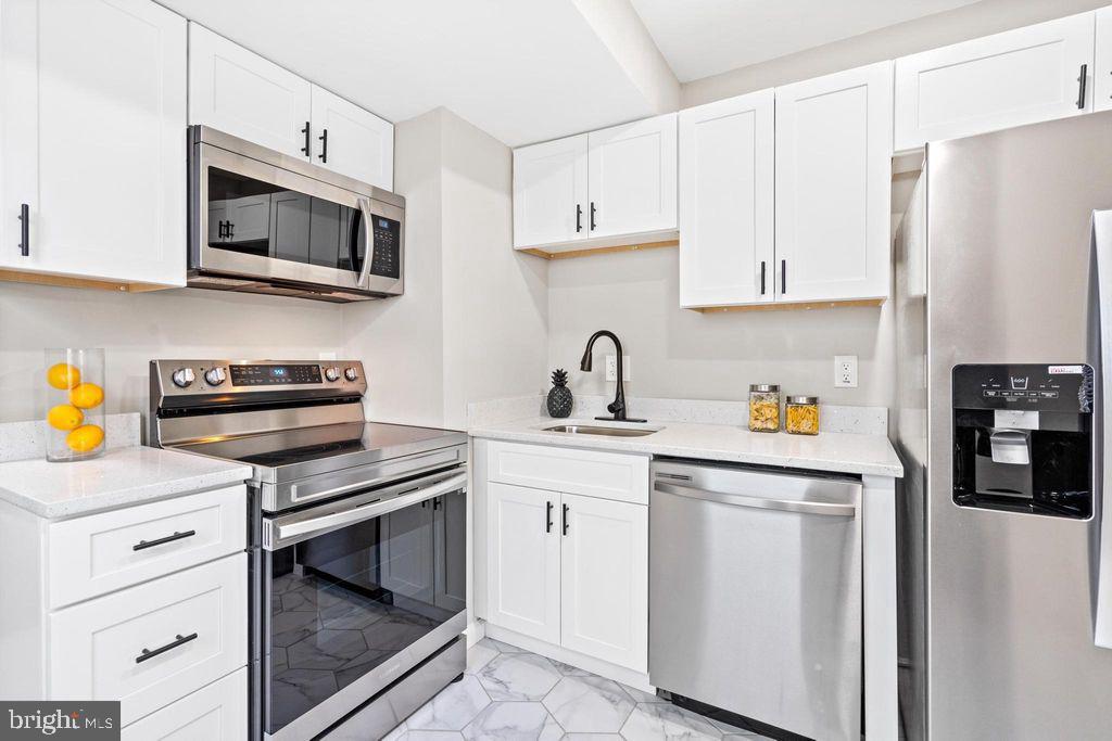424 53rd Street Southeast Washington, DC 20019 - Photo 10 of 40 a kitchen with stainless steel appliances white cabinets and a sink