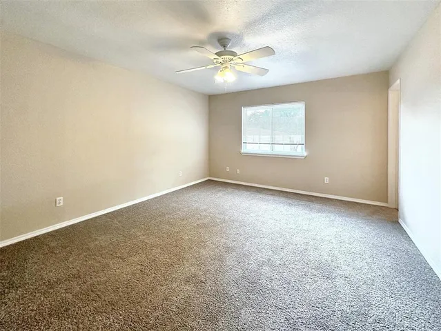 a view of an empty room with a ceiling fan