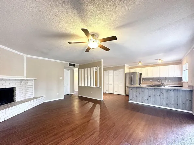 a kitchen with a refrigerator a stove a sink and white cabinets with wooden floor