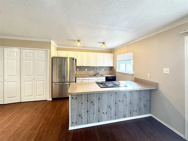 a kitchen with a refrigerator a stove a sink dishwasher and wooden cabinets with wooden floor