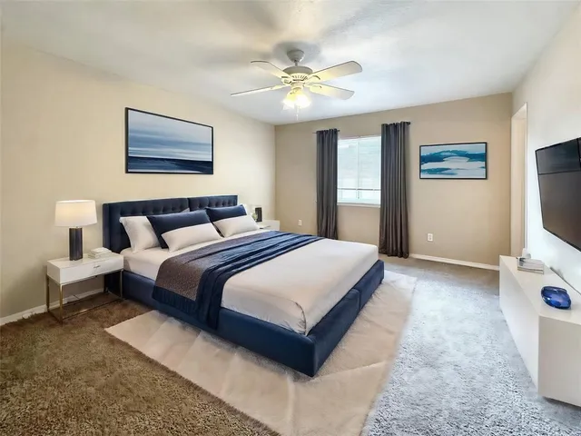 an empty room with windows and chandelier fan