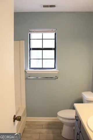 a bathroom with a sink and mirror with toilet