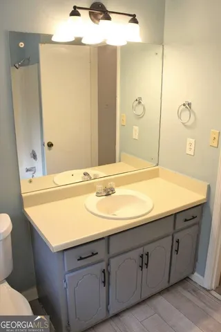 a bathroom with a sink and mirror with toilet